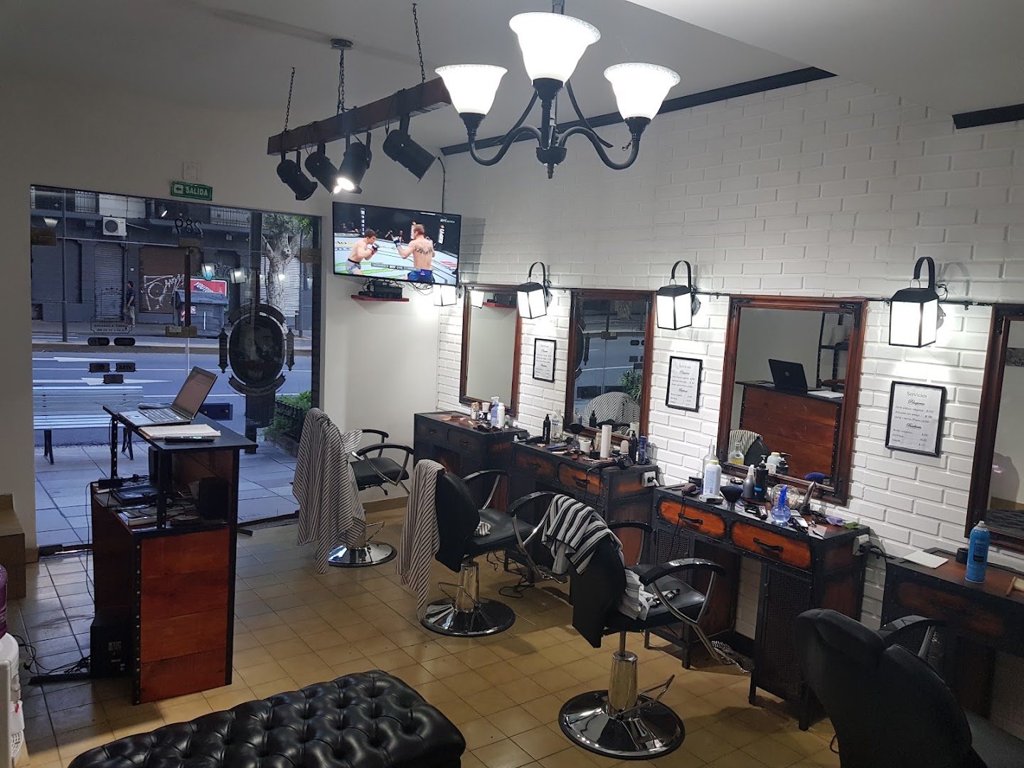 Interior de la Barbería Pedro Navaja en Barracas, con sillones de barbero, espejos y araña de luces