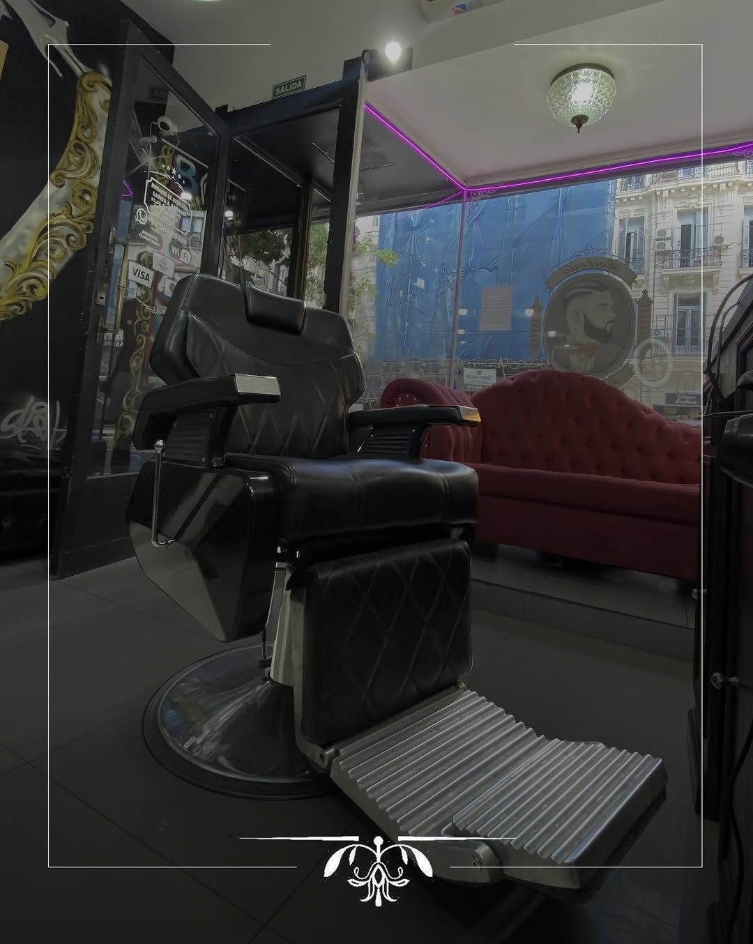 Sillón de barbero junto a la ventana del local